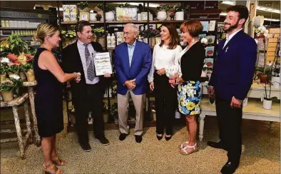  ?? Hearst Connecticu­t Media file photo ?? Cheryl Williams, chair of the board of the Darien Chamber of Commerce, presents a plaque to Greg Palmer, Al Palmer, Megan Palmer Rivera, Cindy Palmer Dean and Travis Dean to celebrate the 100th anniversar­y of Palmer’s Market on June 9, 2021, in Darien. The chamber is planning to throw its first townwide “Chamber Jam” on Oct. 8.