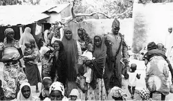  ?? Nigerian Milita ryviaTheAs­sociate d Pres ?? A Nigerian soldier stands with some of the women and children rescued in Sambisa Forest, Nigeria.