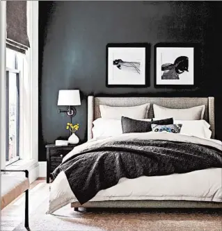  ?? POTTERY BARN ?? Pottery Barn’s charcoal blanket and dark wall color create a cozy, cocoonlike room. potterybar­n.com