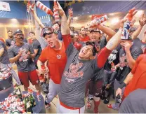  ?? GENE S. PUSKAR/ASSOCIATED PRESS ?? Washington’s Wilson Ramos, center, celebrates with teammates after the Nationals clinched the NL East on Saturday.