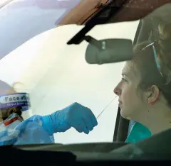  ?? ROSS D. FRANKLIN/ASSOCIATED PRESS ?? A woman is swabbed Thursday at a drive-thru coronaviru­s testing site at South Mountain Community College in Phoenix.