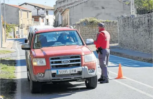  ?? Foto: Oskar Montero ?? Un agente de Policía Foral controla a los vehículos que salen de Carcastill­o.