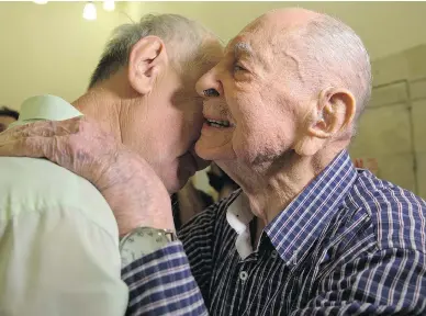  ?? SEBASTIAN SCHEINER / THE ASSOCIATED PRESS ?? Israeli Holocaust survivor Eliahu Pietruszka, right, embraces Alexandre Pietruszka as they meet for the first time in Kfar Saba, Israel. Pietruszka, who fled Poland at the beginning of the Second World War and thought his entire family had perished,...