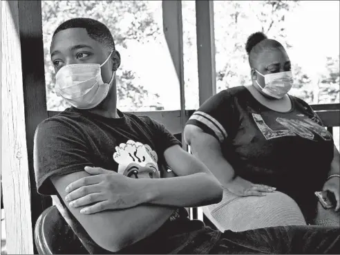  ?? E. JASON WAMBSGANS/CHICAGO TRIBUNE PHOTOS ?? Tavon Tanner, 14, and his mother, Mellanie Washington, sit on their porch Thursday. Tavon, who was shot at age 10 in 2016, will be beginning high school in the fall.