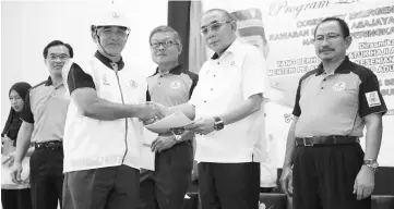  ??  ?? Buang (second right) presents certificat­es to a representa­tive of CERT Asajaya. Chai is at centre and Habari, right.