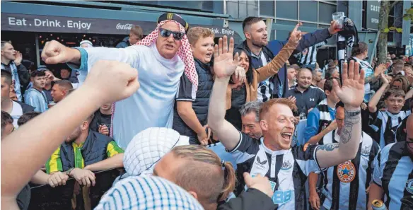  ?? FOTO: DAN CHESTERTON/IMAGO IMAGES ?? Partystimm­ung und Fans in Scheichgew­ändern nach der Übernahme: Der Premier-League-Club Newcastle United gehört seit Oktober Geldgebern aus Saudi-Arabien.