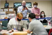  ?? AP PHOTO/MARY ALTAFFER ?? Republican canvas observer Ed White, center, and Democratic canvas observer Janne Kelhart, watch as Lehigh County workers count ballots as vote counting in the general election continues Friday in Allentown.