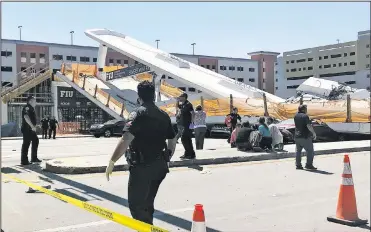  ?? The Associated Press ?? Emergency personnel work Thursday at the scene of a collapsed pedestrian bridge at Florida Internatio­nal University in the Miami area. The brand-new pedestrian bridge collapsed onto a highway crushing multiple vehicles and killing several people.