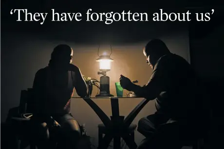  ?? VICTOR J. BLUE/THE NEW YORK TIMES ?? Ana Luz Pérez watches her boyfriend, Carlos Rivera, eat dinner by lantern light in her apartment Wednesday in the Luis Lloréns Torres housing project in San Juan, Puerto Rico. More than a week after Hurricane Maria hit, the island is a woozy empire of...