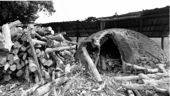  ??  ?? Worker filling up the ‘gok’ for burning process. - Bernama photo