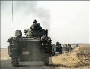  ??  ?? The Associated Press
ON THE MOVE: Turkish troops head to the Syrian border Saturday in Karkamis, Turkey. Turkey on Wednesday sent tanks across the border to help Syrian rebels retake the key Islamic State-held town of Jarablus and to contain the...