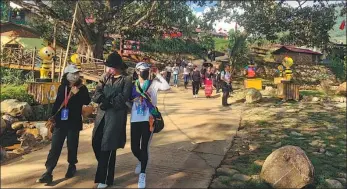  ?? PROVIDED TO CHINA DAILY ?? Tourists visit a village of the Wa ethnic group in Cangyuan Wa autonomous county, Yunnan province.