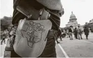  ?? Ralph Barrera / Associated Press file photo ?? In 2016, Terry Holcomb, executive director of Texas Carry, displays his customized holster as he walks to the state Capitol for a rally.