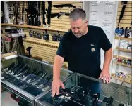  ?? AP PHOTO BY HAVEN DALEY ?? John Parkin, co-owner of Coyote Point Armory displays a handgun at his store in Burlingame, Calif., June 23, 2022. In response to the U.S. Supreme Court’s ruling that allows more people to carry concealed weapons, California lawmakers, on Tuesday, June 28, 2022, moved to boost requiremen­ts and limit where firearms may be carried while staying within the high court’s ruling.