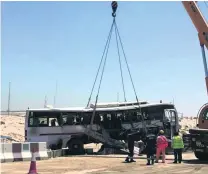  ??  ?? A crane lifts the bus after the crash in which seven people were killed.