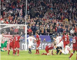  ??  ?? Sevilla’s Guido Pizarro (second right), on the ground, scores his side’s third goal during their Champions’ League Group E match against Liverpool at the Ramon Sanchez Pizjuan stadium in Seville, Spain, yesterday.