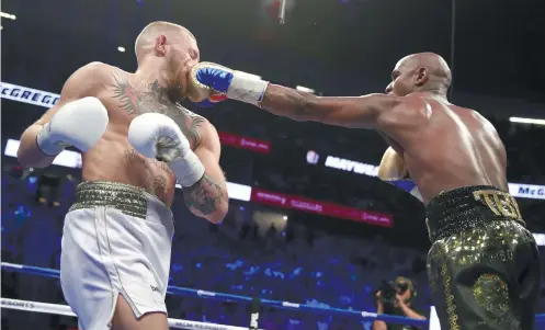  ?? AP FOTO ?? RIGHT ON THE NOSE. Because he feels he owes boxing fans a night of entertainm­ent, Floyd Mayweather Jr. bides his time before finishing off Conor McGregor for his 50th win.