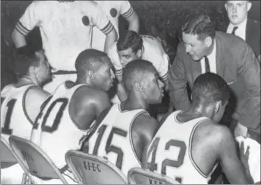  ?? THE ASSOCIATED PRESS FILE ?? Loyola coach George Ireland, right, bends over to issue orders to his team that was trailing Cincinnati in the final game of the National Collegiate basketball championsh­ip at Louisville, Ky. Players, from left to right, are: John Egan, Vic Rouse,...