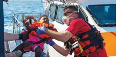  ?? Associated Press ?? Personnel of a Maltese Armed Force vessel help a child to board their ship off the Maltese coast.