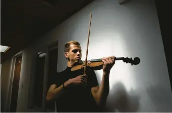  ?? NATHALIA ANGARITA/THE NEW YORK TIMES ?? Venezuelan violinist Victor Rojas on Jan. 25 at his home in Bogota, Colombia. Rojas, who arrived in Colombia in 2018, is one of the beneficiar­ies of a visa program that has offered essential benefits to migrants.