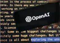  ?? (AP) ?? The OpenAI logo appears on a mobile phone in front of a screen showing part of the company website in in New York.