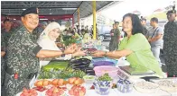  ?? ?? KUNJUNGI: Mohd Sofi bersama isterinya melawat gerai yang ada di Pasar Dayak Kem Penrissen semalam.