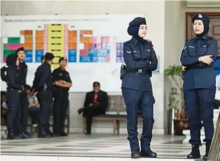  ??  ?? Constant vigilance: Police officers standing guard at the Kuala Lumpur Court Complex during Hasanah’s hearing.