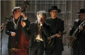  ??  ?? In this Feb. 13, 2011, photo, Bob Dylan, center, performs at the 53rd annual Grammy Awards in Los Angeles.