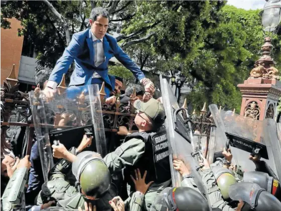  ?? Foto: Efe ?? Guaidó trepa una reja en un intento por acceder a la sede de la Asamblea Nacional, custodiada por la Policía, en enero de 2020.
