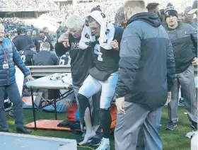  ??  ?? Derek Carr es ayudado por personal de los Raiders de Oakland tras sufrir una lesión ante los Colts de Indianápol­is.