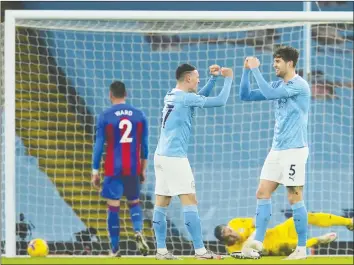  ?? REUTERS ?? John Stones (right) is congratula­ted by teammate Phil Foden after scoring one of his two goals in Manchester City's win over Crystal Palace in Premier League action yesterday.