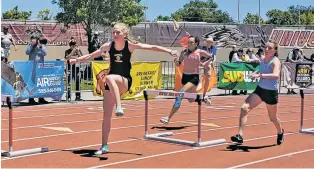  ??  ?? ABOVE: Santa Fe High’s Judith Allison makes the turn during the Class 5A 300-meter hurdles Saturday at the State Track and Field Championsh­ips at Great Friends of UNM Track Complex. Allison won in 44.04 seconds for her first individual title.