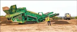  ?? JARROD VALLIERE U-T FILE ?? At the Otay Compost Facility, organic waste goes through a grinder. Resulting mulch is then covered, watered and pumped with oxygen to speed decomposit­ion.