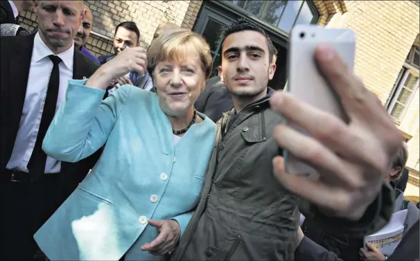  ?? Foto: Sean Gallup/Getty Images ?? Der blev taget selfies, da den tyske kansler, Angela Merkel, forleden besøgte et asylcenter i Berlin.