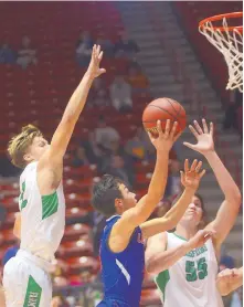  ?? ADOLPHE PIERRE-LOUIS/JOURNAL ?? Los Lunas’ Devon Heybone, center, drives to the basket between the converging defense of Farmington’s Sol Rascon, left, and David Riley.