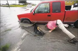  ?? BRETT COOMER Houston Chronicle ?? A MAN tries to dislodge his truck from a ditch f looded by Tropical Storm Imelda in Houston. The storm also threatened to drench parts of Louisiana’s southwest.