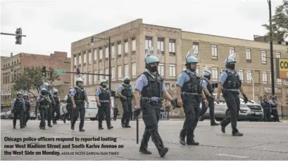  ?? ASHLEE REZIN GARCIA/SUN-TIMES ?? Chicago police officers respond to reported looting near West Madison Street and South Karlov Avenue on the West Side on Monday.