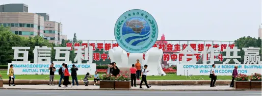  ??  ?? Le 3 mai 2018, le Sommet de l’OCS est annoncé dans les rues de Qingdao.