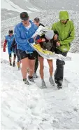  ??  ?? Der Zugspitzla­uf 2008: Helfer stützen eine völlig durchgefro­rene Läuferin.