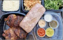  ?? WENDELL BROCK FOR THE ATLANTA JOURNAL-CONSTITUTI­ON ?? This takeout order from Fire Hen includes a whole chicken with French bread, dipping sauces, and sides (mashed potatoes, fondu mac and cheese and mixed green salad).