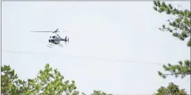  ?? Jeremy stewart ?? A helicopter flies over the woods on Dugdown Mountain south of Cedartown near the Polk-Haralson county line on Monday, Aug. 2, in an effort to find missing 83-year-old Barbara McCray.