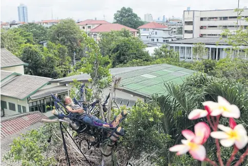  ??  ?? GOING NOWHERE: ‘It is the best spot from which to see the sunrise and sunset,’ says Jadej Manopas, who is vowing to protect the last banyan tree in his neighbourh­ood.