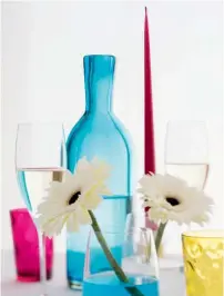  ??  ?? En guise de petits vases pour les fleurs, de simples verres remplis d’eau teintée au colorant alimentair­e.