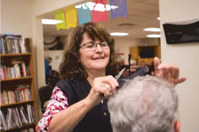  ?? OLIVIA HARLOW/THE NEW MEXICAN ?? Fabiola Guillen cuts Earl Jaramillo’s hair Oct. 24 at the Pasatiempo Senior Center.