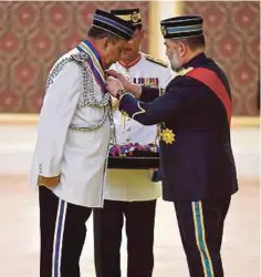  ??  ?? SULTAN Muhammad V (kanan) berkenan mengurniak­an Darjah PGPP kepada Mohd Mokhtar di Istana Negara, semalam.