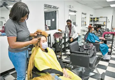  ?? PAUL W. GILLESPIE/CAPITAL GAZETTE ?? Nadine Djuiko, owner of Nadine’s Hair Braiding in Bowie, works on Debrah Jackson’s hair on Tuesday.