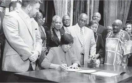  ?? KIM HAIRSTON/BALTIMORE SUN ?? Mayor Stephanie Rawlings-Blake, with City Council President Bernard C. “Jack” Young behind her, join community and business leaders for a signing ceremony of three pieces of legislatio­n for the Port Covington project.