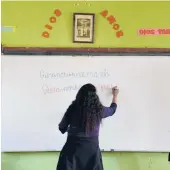  ?? MARTIN MEJIA/AP 2021 ?? Teacher Carmen Cazorla writes in the Quechua language, spoken by about 10 million people, during a class at a public primary school in Licapa, Peru.