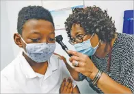  ?? ROGELIO V. SOLIS ASSOCIATED PRESS ?? Janice Bacon, a primary care physician with Central Mississipp­i Health Services, gives Jeremiah Young, 11, a back-to-school physical Aug. 24 at the Community Health Care Center on the Tougaloo College campus in Tougaloo, Miss.
