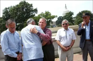  ?? Gerald Herbert/Associated Press ?? Ed Shames, center, hugs Ed McClung, center left, both members of the famed World War II Army Company E of the 506th Regiment of the 101st Airborne, at the Library of Congress in Washington Wednesday, July 16, 2003. Fellow veterans are Jack Foley, left, Joe Lesniewski, right, and Shifty Powers, far right.